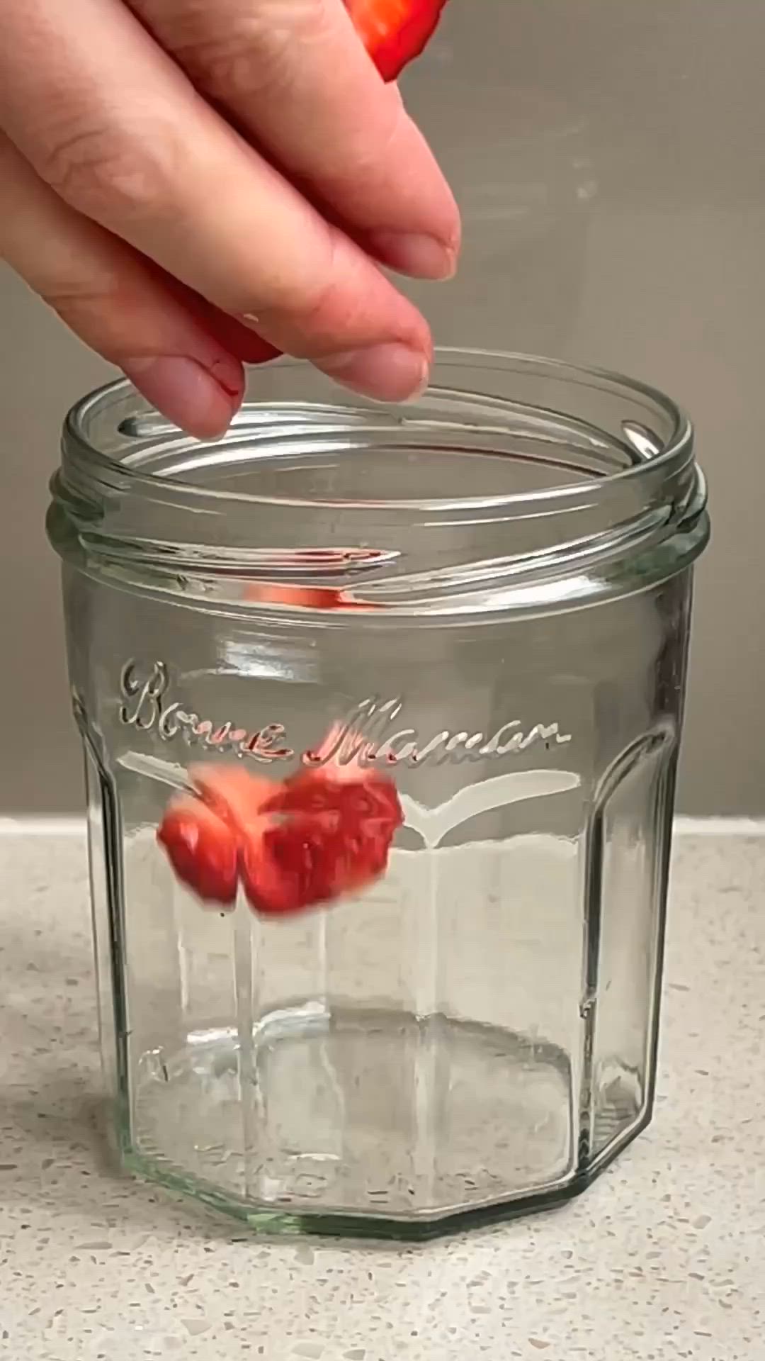 This may contain: strawberries in a mason jar with a tissue dispenser on the top