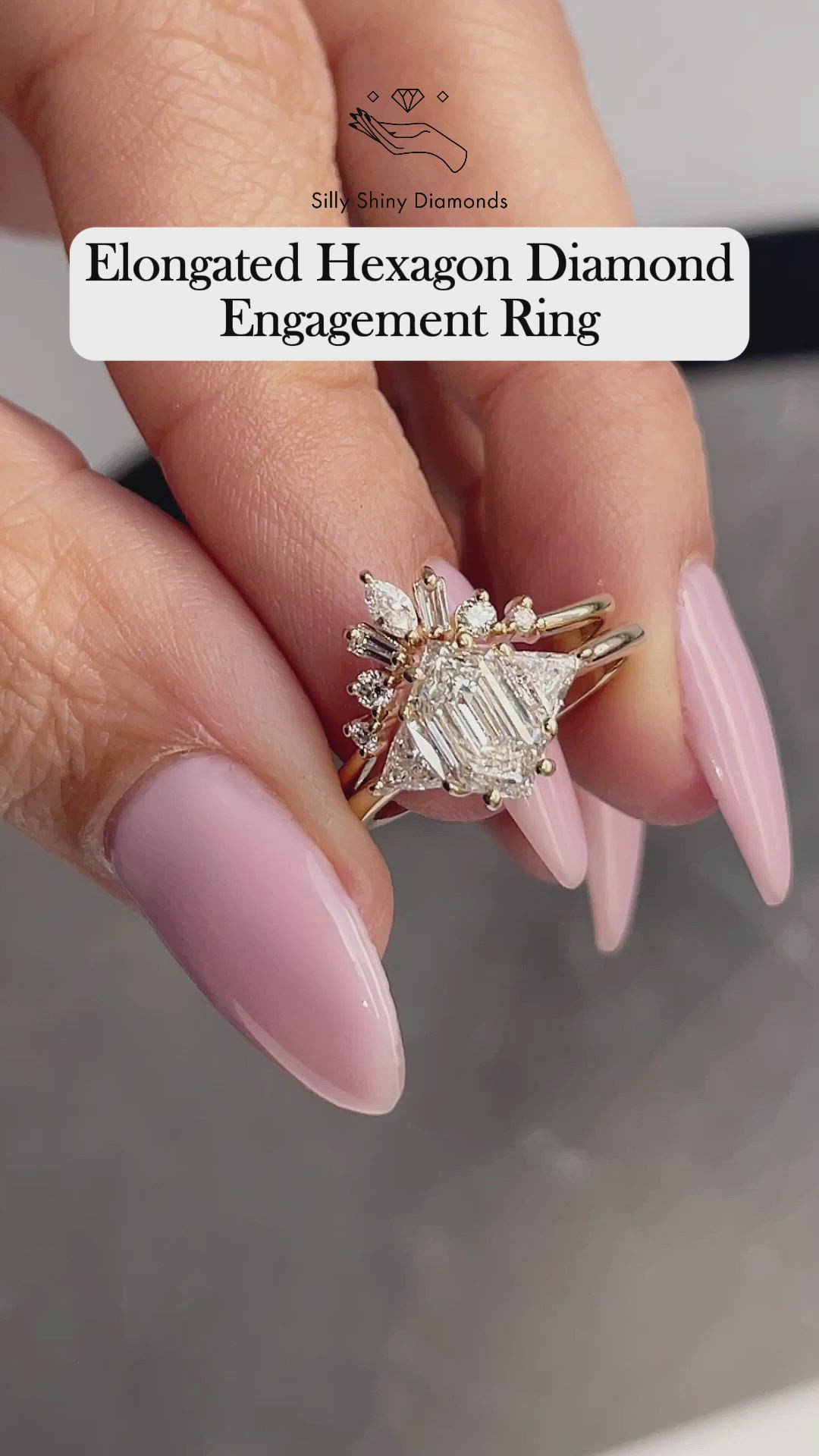 This may contain: a woman's hand holding an engagement ring with three diamonds on top of it