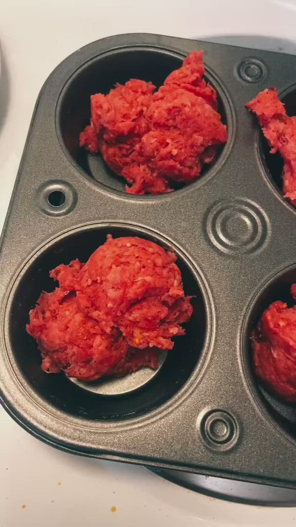 This may contain: four muffin tins filled with red meat sitting on top of a white counter