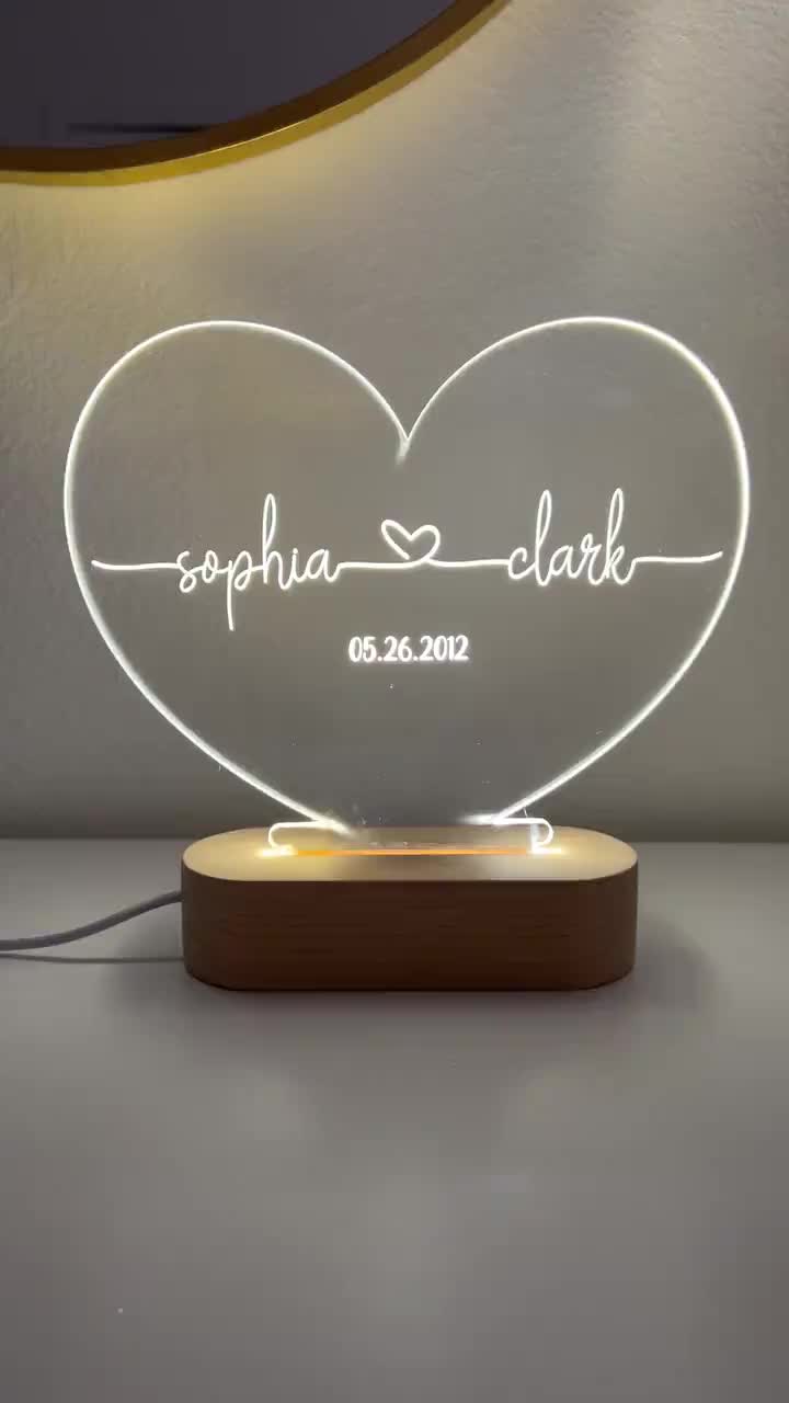 This may contain: a personalized heart shaped light up with the name and date on it, sitting on top of a table