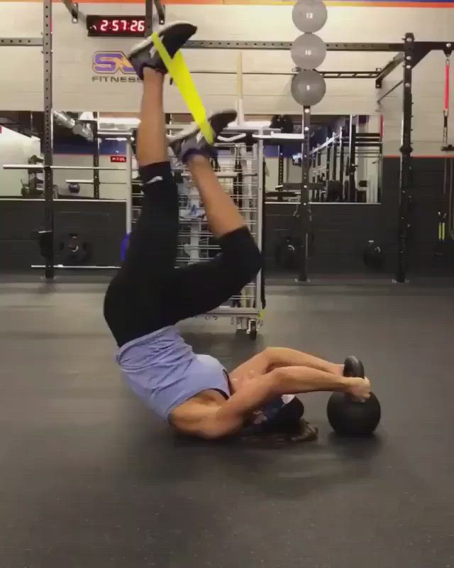 This may contain: a man is doing an exercise with a medicine ball on his back in a gym