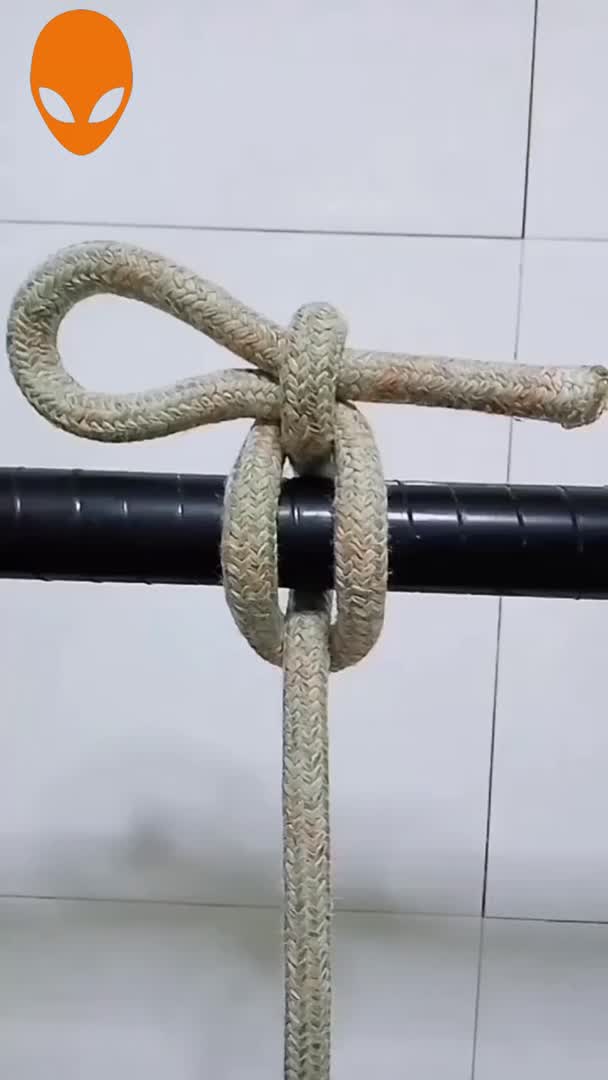 This may contain: a close up of a rope with an alien head in the background on a white tile wall