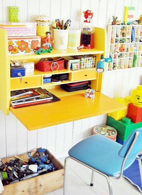 Colorful yellow fold out desk with storage space.