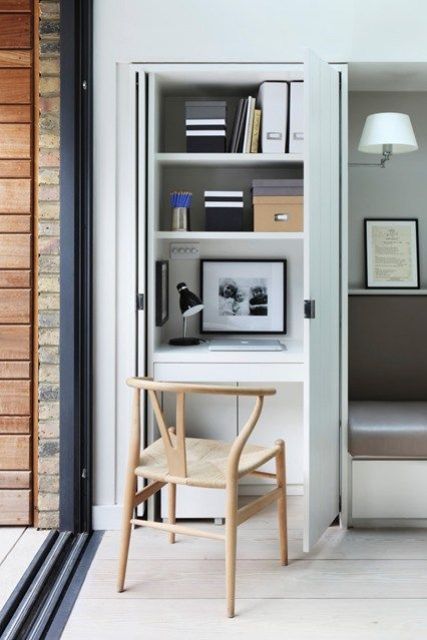 Small workspace with space-saving pocket doors is concealed in a kitchen cupboard.