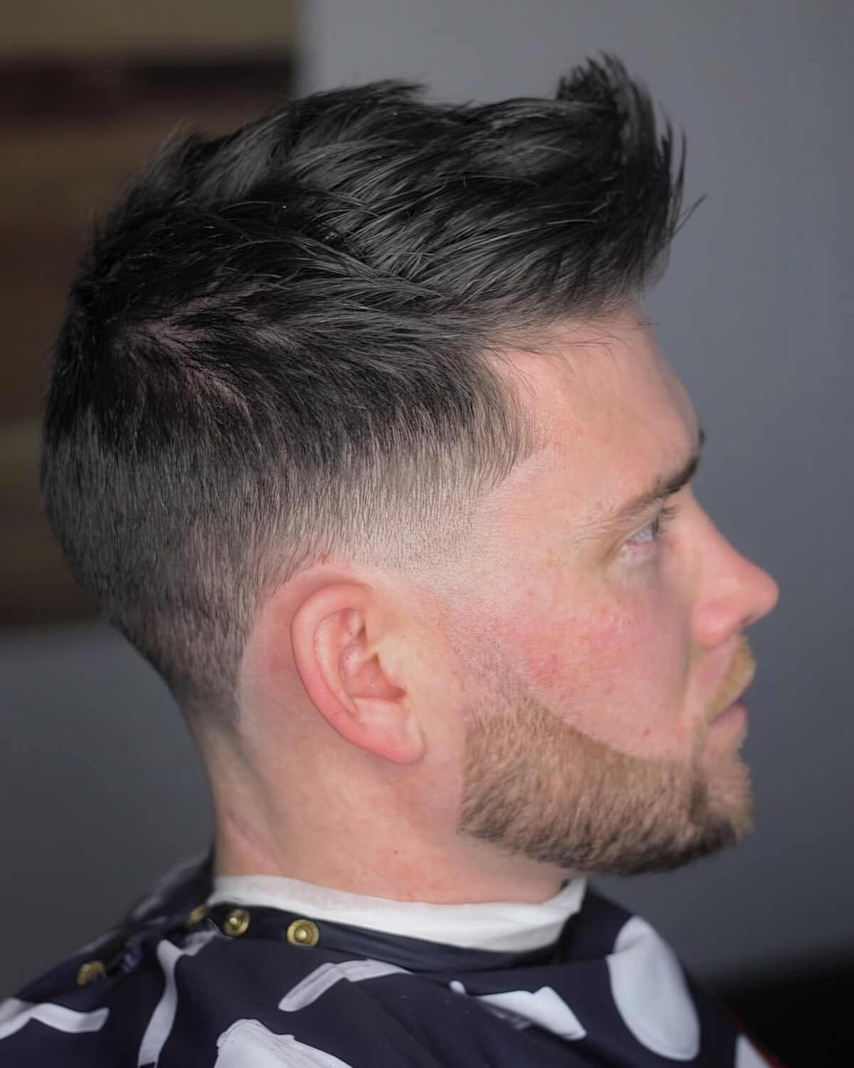 A classic faux hawk is combined with some well-trimmed facial hair for unique style.