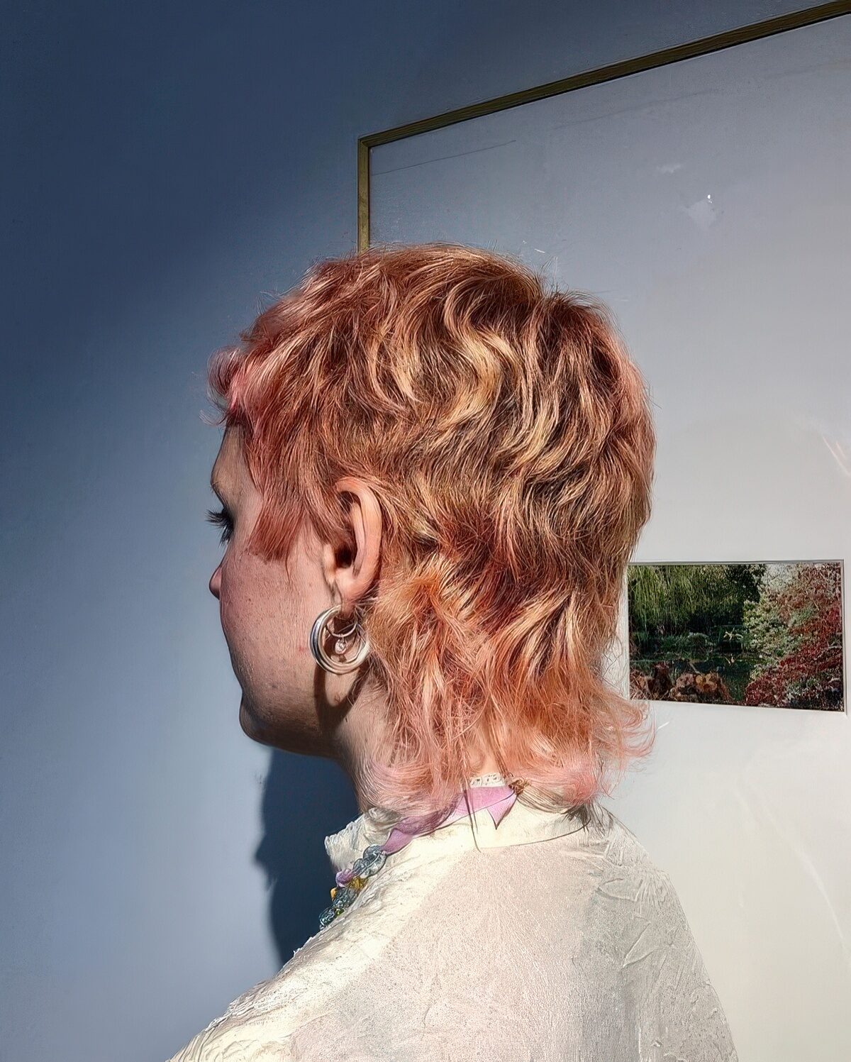 A ginger to pink short mullet with short bangs and waves is a catchy and bold idea to make a statement with.