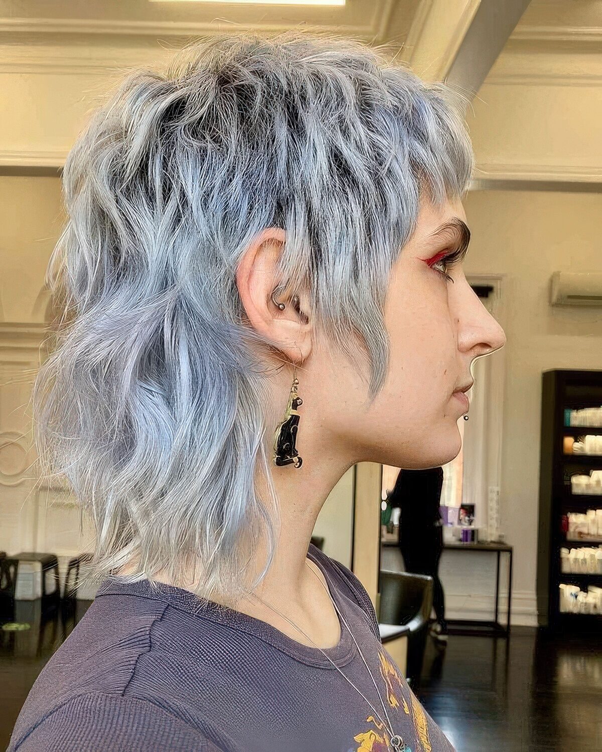 A pale blue short mullet with dimension and waves is a catchy and bold idea that looks rock-style.