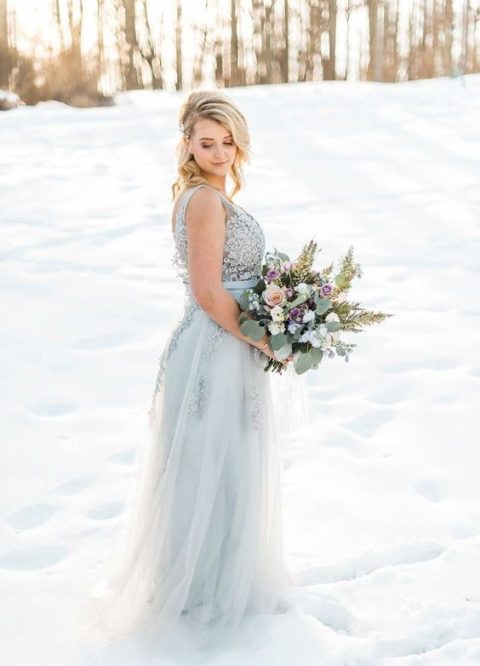 An icy blue sleeveless winter wedding dress with a lace bodice, a tulle and lace skirt is very delicate and chic.