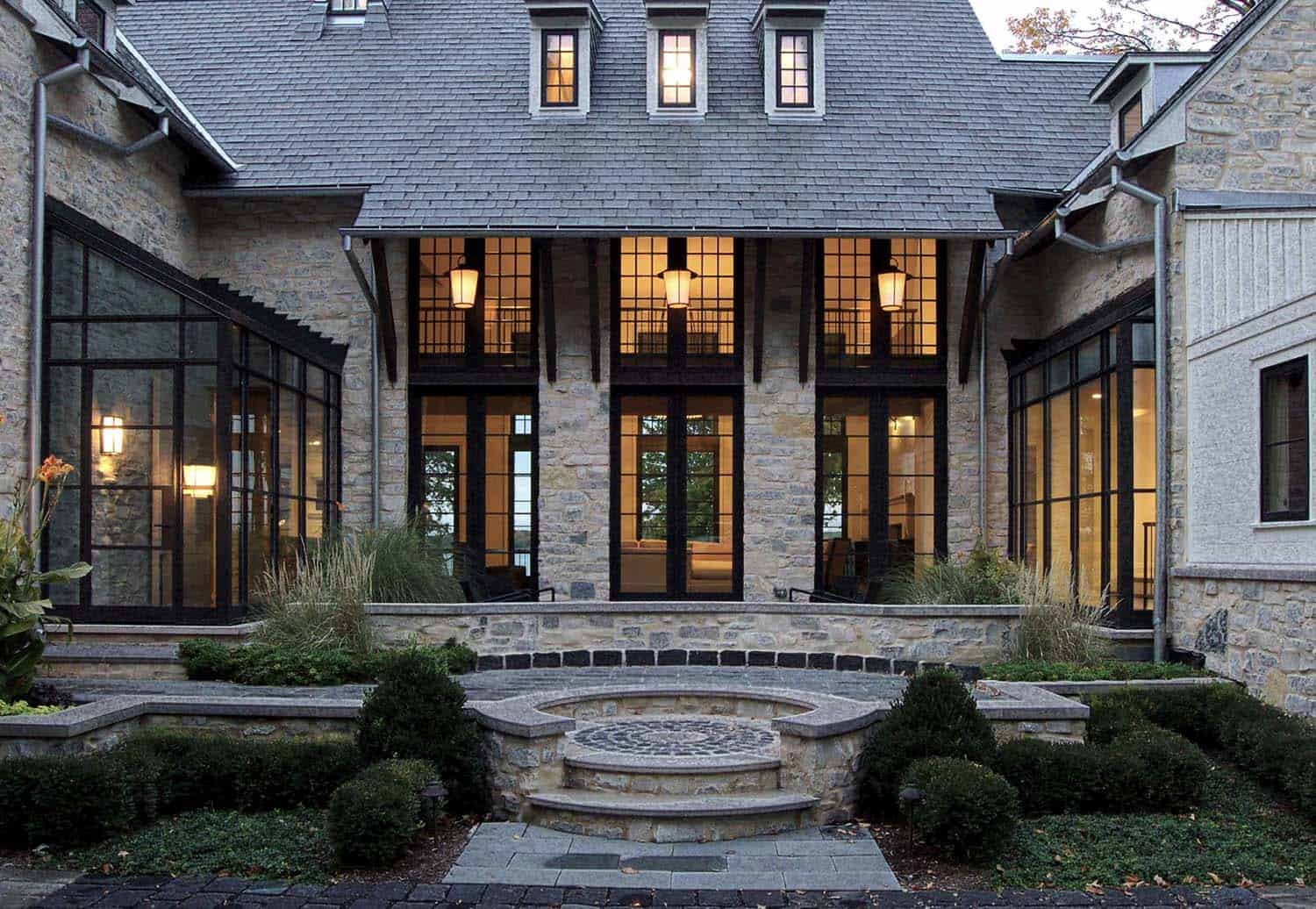 A luxury stone house entryway with large floor-to-ceiling windows