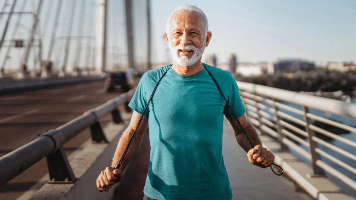 An older man runs across a bridge