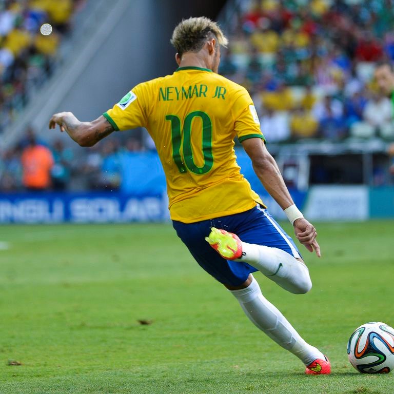 Neymar com a camisa da Seleção Brasileira de Futebol chutando uma bola