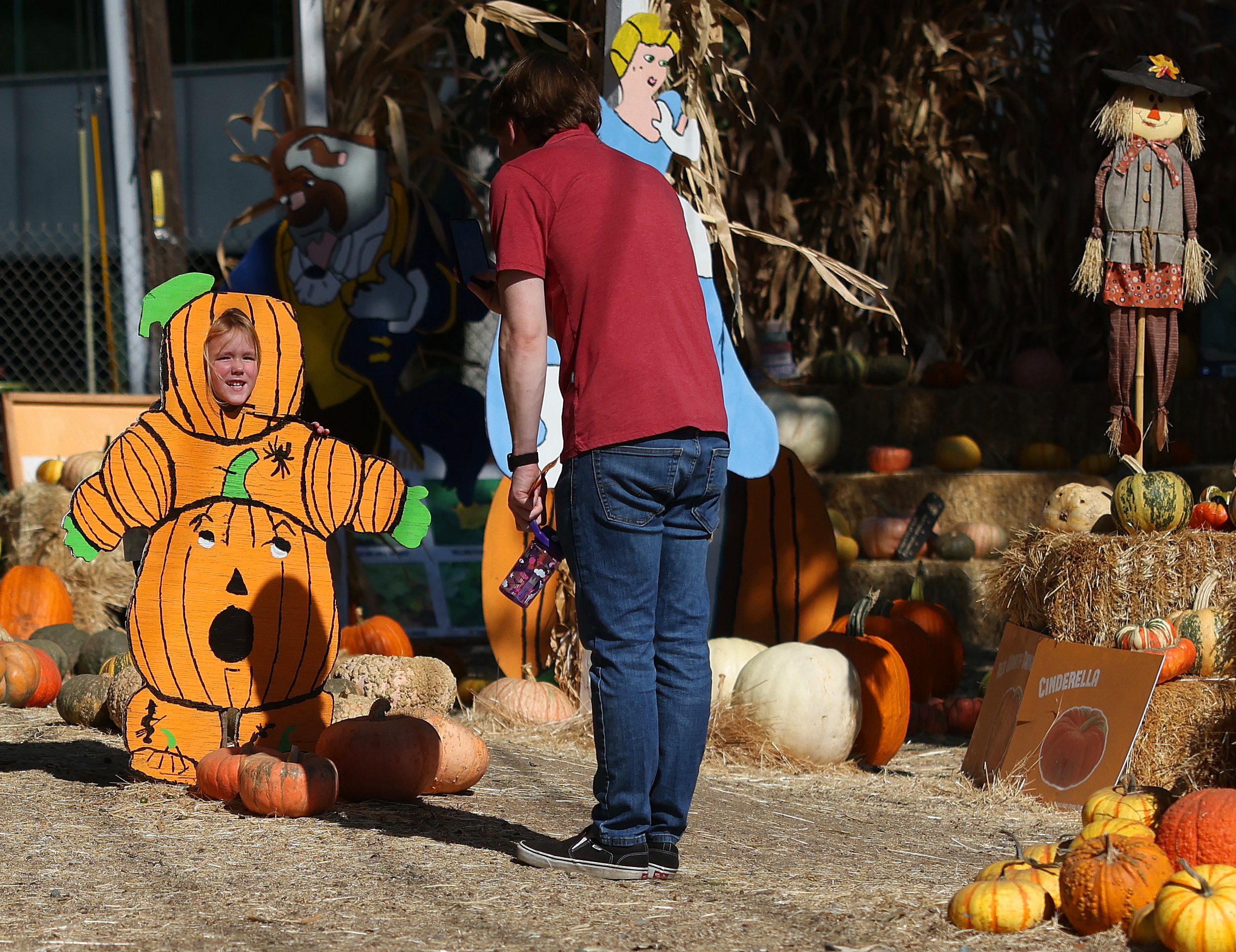 Katy Thompson ,4, left, poses at a Halloween display as Josh Thompson, right, looks on during a visit to a pumpkin patch on Wednesday, Oct. 18, 2023, in Walnut Creek, Calif. Warm weather is forecast across the Bay Area over the next couple of days. (Aric Crabb/Bay Area News Group)