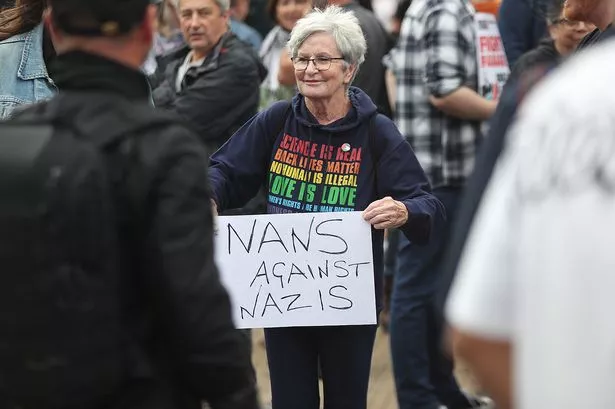 A protester defending the Abdullah Quilliam Mosque in Liverpool holds a placard reading "Nans against Nazis" on August 3, 2024 against the 'Enough is Enough' demonstration (not seen) called in reaction to the fatal stabbings in Southport on July 29. UK police prepared for planned far-right protests and other demonstrations this weekend, after two nights of unrest in several English towns and cities following a mass stabbing that killed three young girls. (Photo by IAN COOPER / AFP) (Photo by IAN COOPER/AFP via Getty Images)