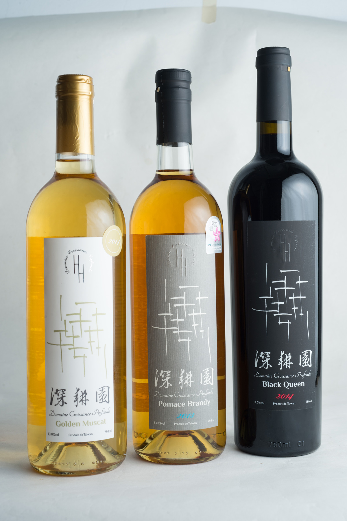 深耕園金香白葡萄酒、黑后紅葡萄酒，以及用黑后葡萄果渣蒸餾而成的白蘭地（中），獲得國際肯定。（攝影：李明宜）