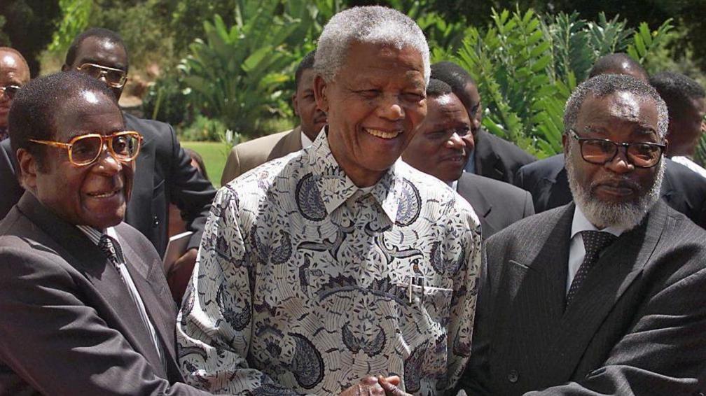 South African President Nelson Mandela (C) and his counterparts, Zimbabwean President Robert Mugabe (L) and Namibia's Sam Nujoma (R), shake hands after a joint press conference in Pretoria, 05 March 1999.