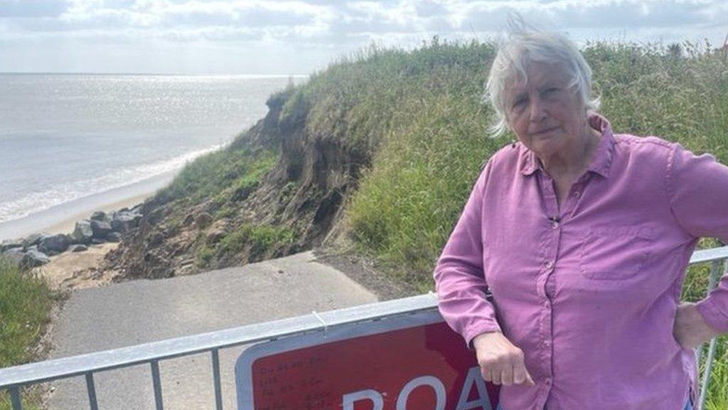 woman standing beside road closed sign