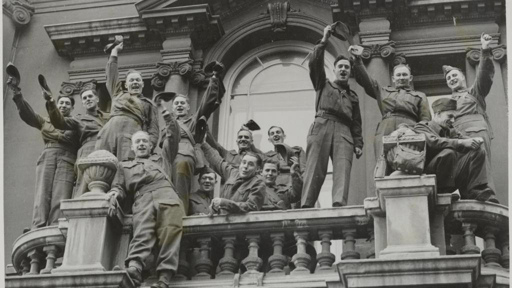 Some of the Canadians waving hats from the balcony of the Beaver Club