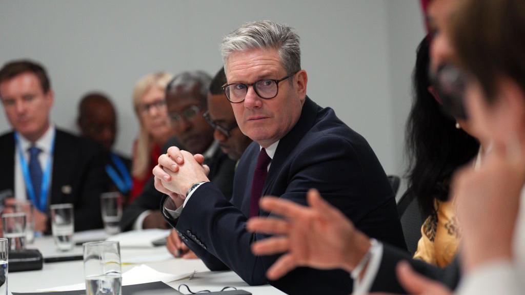 UK Prime Minister Keir Starmer attends a financial meeting with international colleagues as part of the COP29 climate conference meeting on 12 November, 2024 in Baku, Azerbaijan. He is in the centre of the image, wearing a dark suit and has his hands clasped together