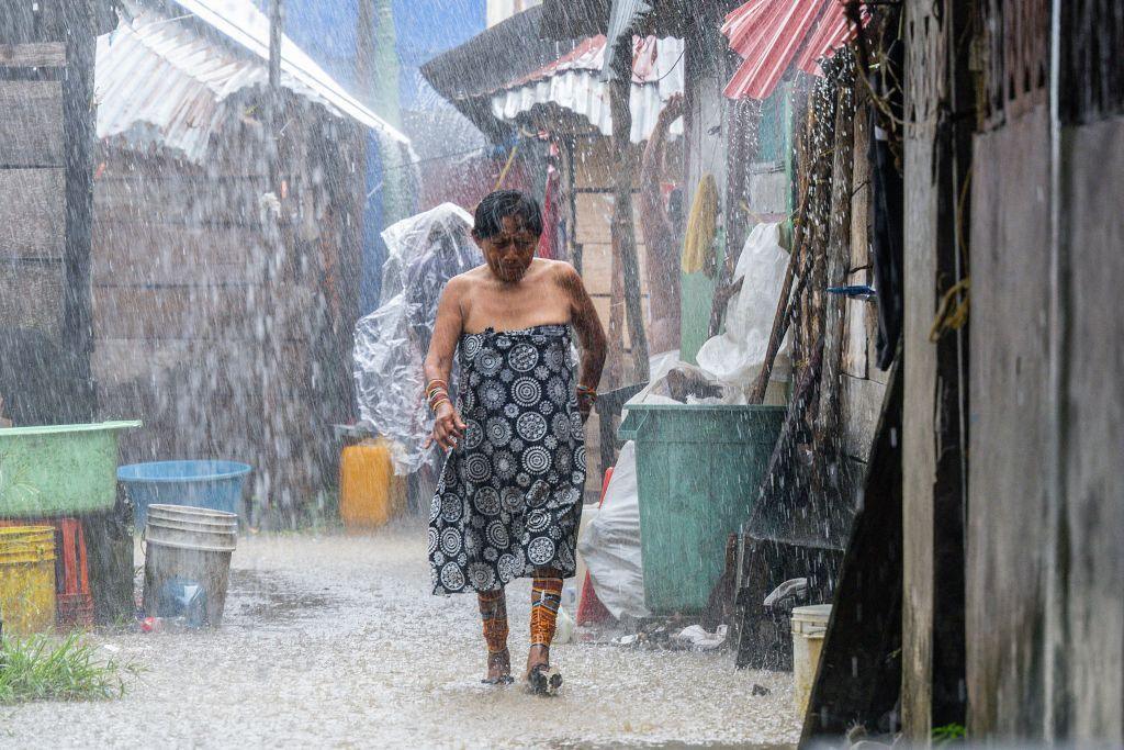 A Guna Indigenous woman walks under the rain on the island of Carti Sugtupu, in the Indigenous Guna Yala Comarca, Panama, in the Caribbean Sea, on August 28, 2023.