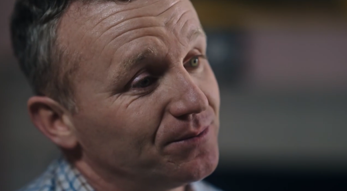 Sgt Steven Peters, wearing a checked shirt, looks away from the camera with a neutral expression