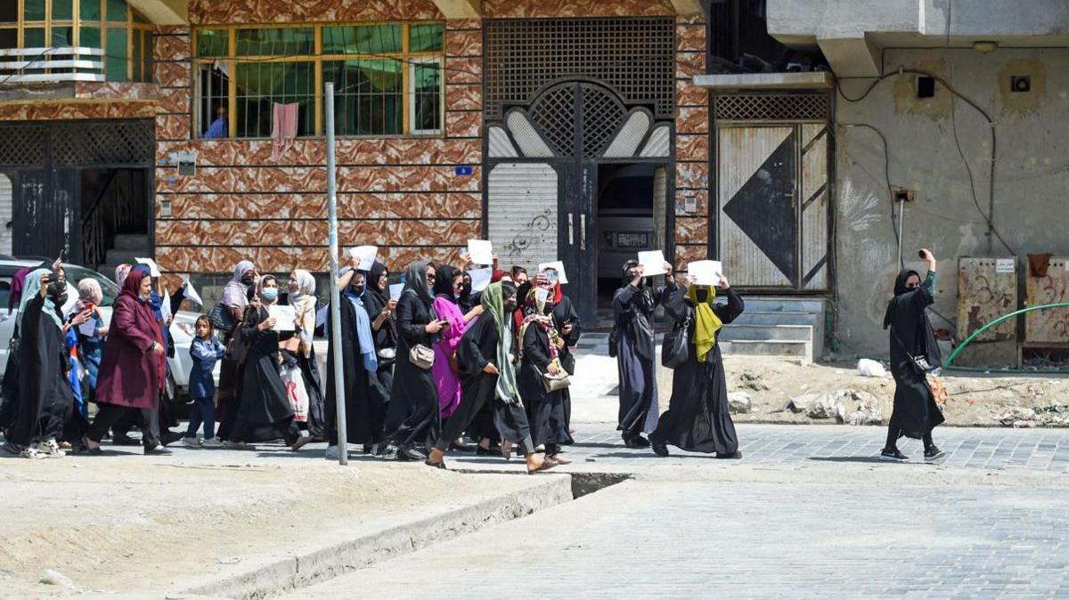 Afghan women hold placards as they march to protest for their rights, in Kabul on April 29, 2023