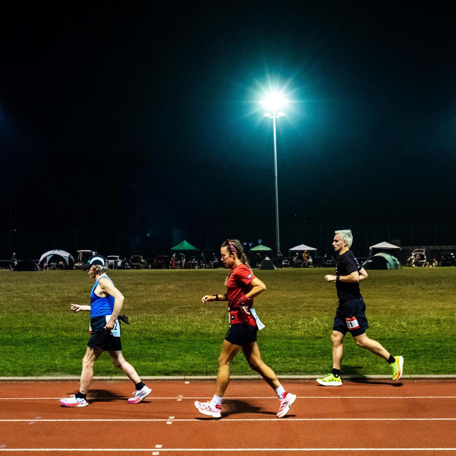 Competitors run through the night in the Sri Chinmoy 24hr Track Race in Battersea Park