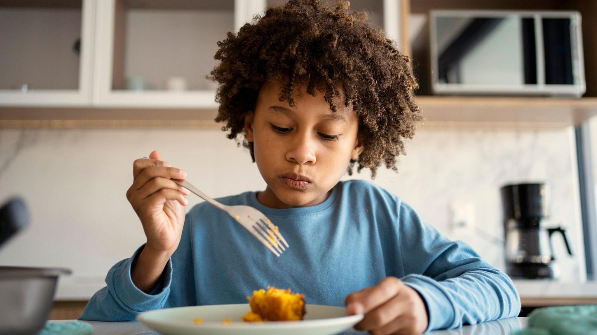 child eating at a kitchen table