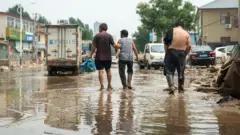 三人走在涿州被洪水淹沒的街道上