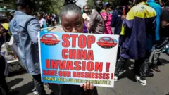 肯尼亞中小企業商販手持標語牌並高喊口號，抗議中國人擁有從事進口、製造和分銷的企業