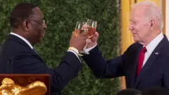 12月14 日，美國總統拜登（右）和塞內加爾總統麥基·薩爾（左）在白宮舉行的美非領導人峰會晚宴上敬酒