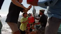 美國夏威夷毛伊島居民組成人鏈從志願者救援船卸下救災物資（13/8/2023）