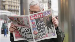 一名男子在倫敦閲讀一份《太陽報》，報紙上有張威廉王子與凱特王妃在溫莎一個農莊商店附近的錄像截屏。