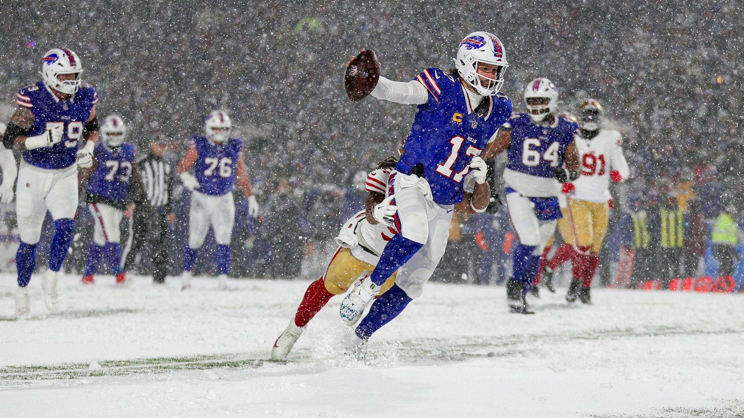 Buffalo Bills quarterback Josh Allen runs with the ball against the San Francisco 49ers as snow falls in the stadium