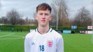 Footballer Sam Harding in his schoolboy white England kit with an 18 on the front of the shirt and the Three Lions badge