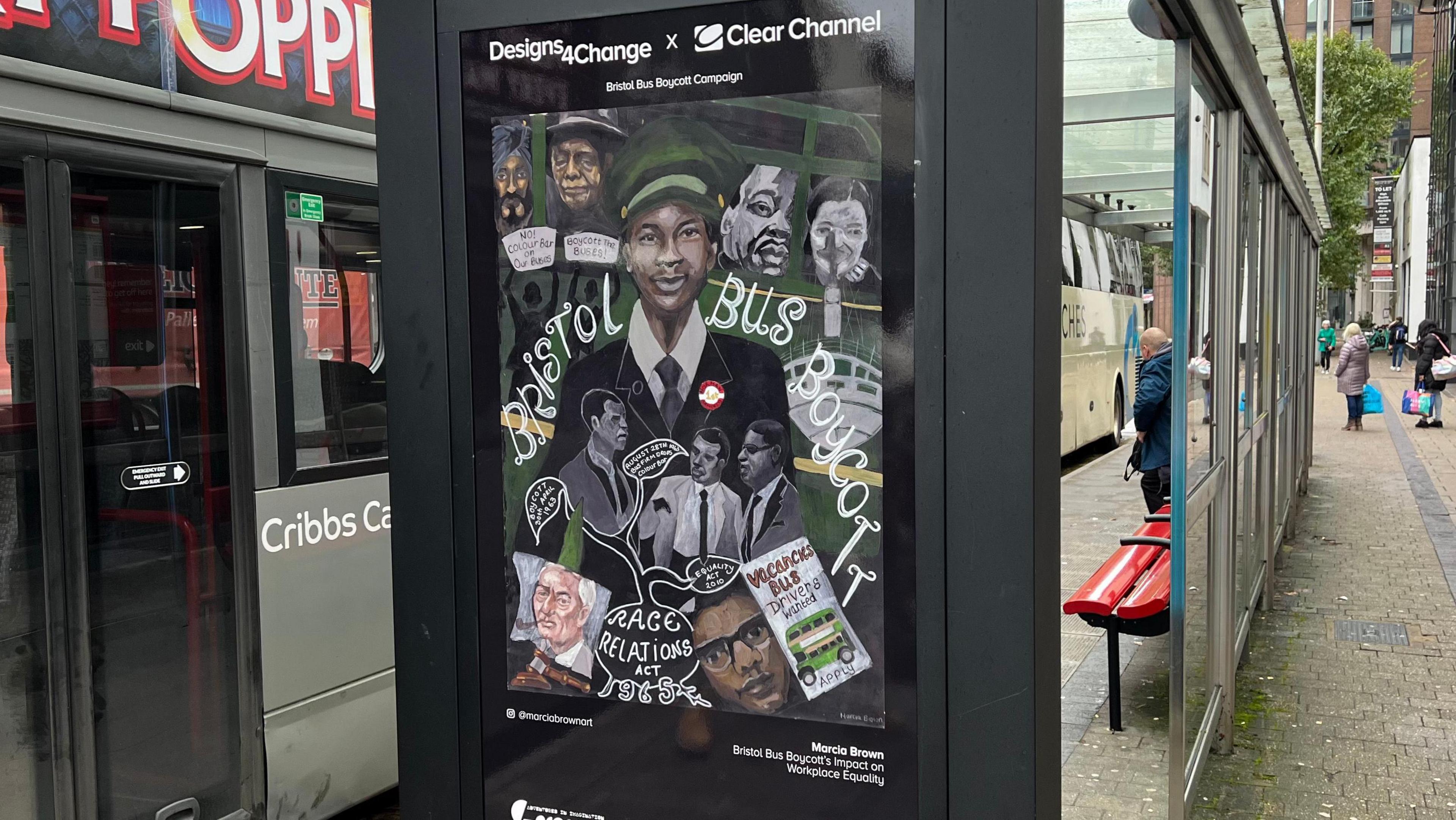 A poster at a bus stop in Bristol shows important participants in the Bristol Bus Boycott. Behind the poster is a parked bus and people waiting at the bus stop.