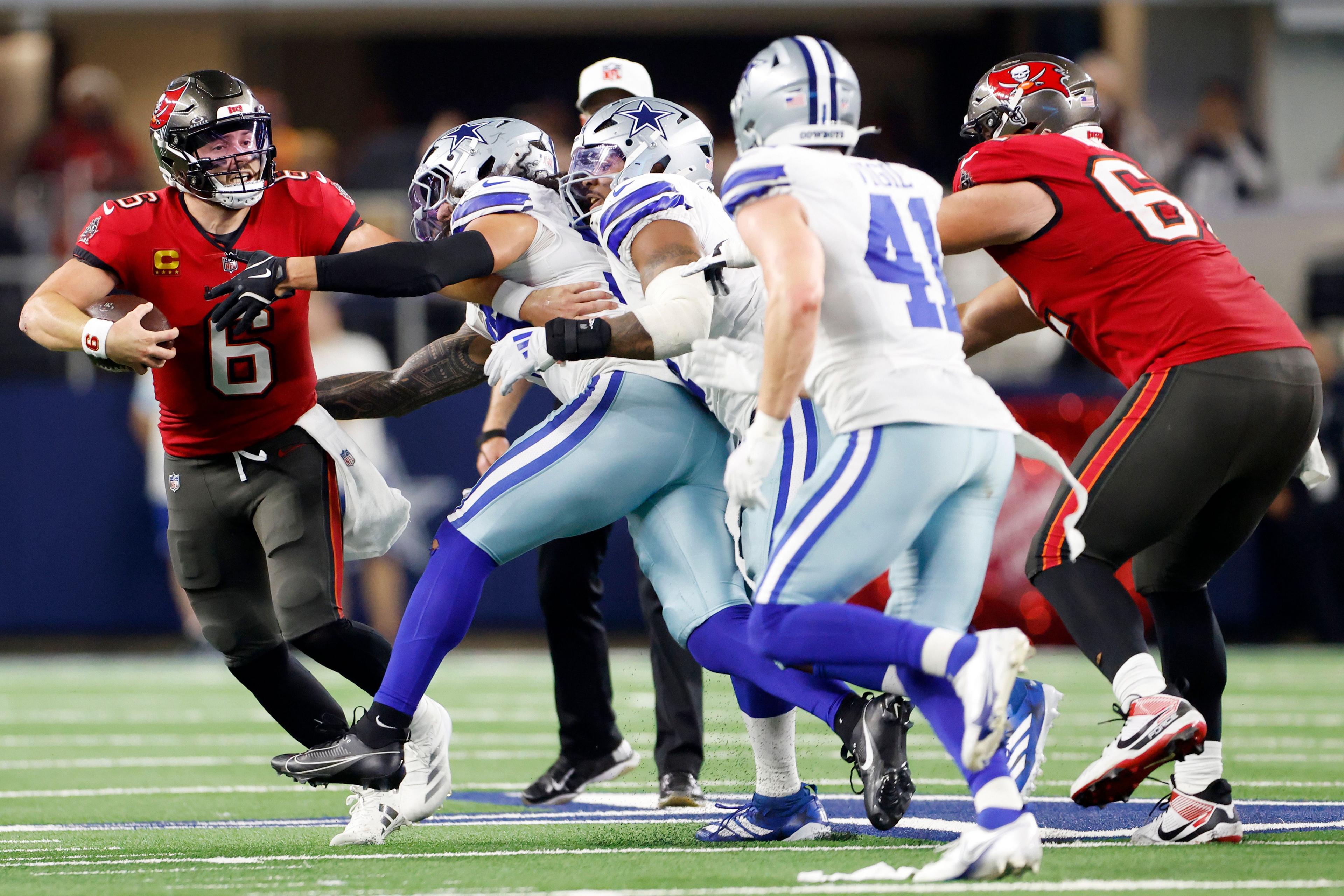 Baker Mayfield of the Tampa Bay Buccaneers is tackled by a host of Dallas Cowboys defenders