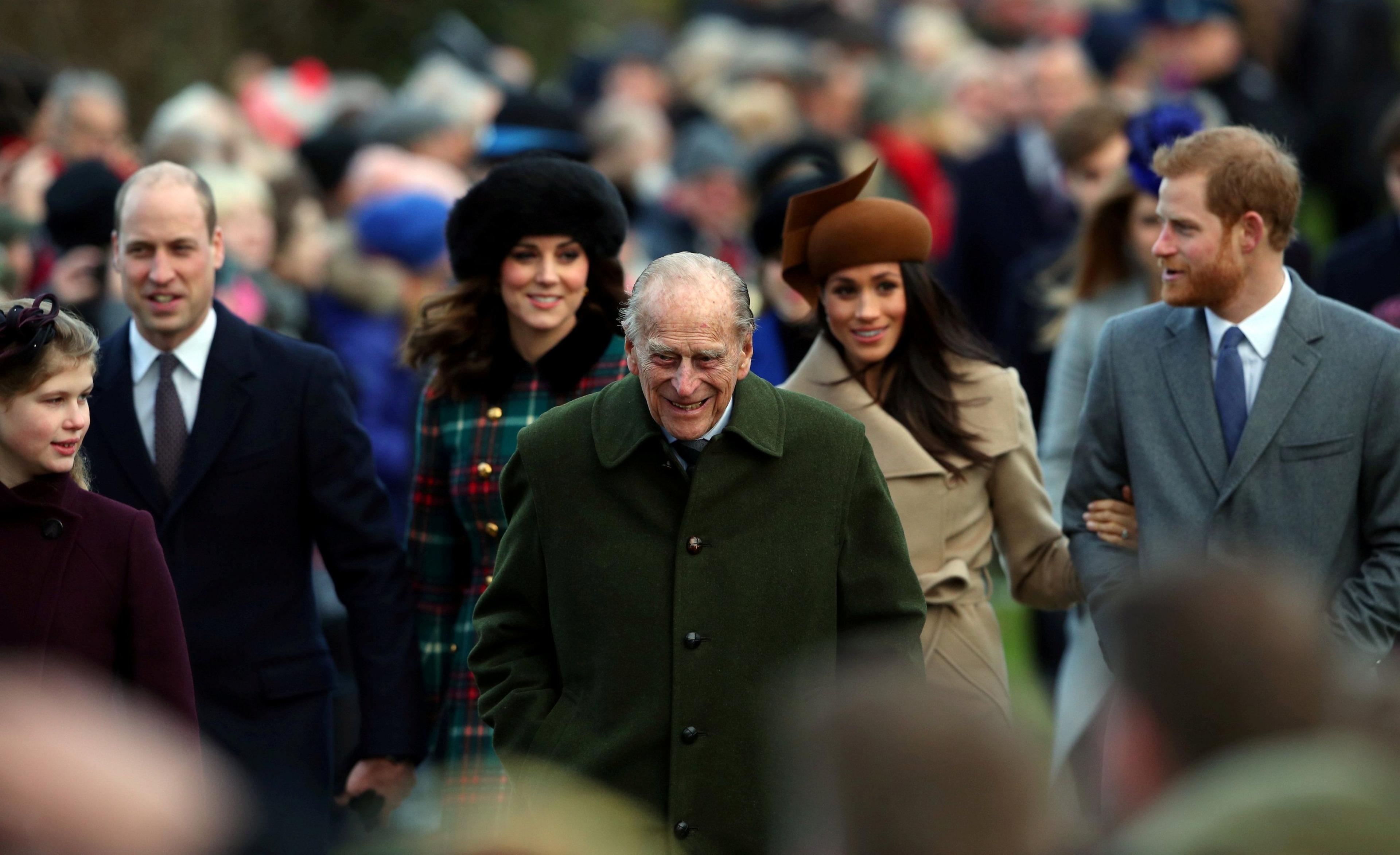 Prince Philip, the Duke of Edinburgh, leads Prince William, Duke of Cambridge, Catherine, Duchess of Cambridge, Meghan Markle and Prince Harry. Crowds can be seen in the background. 