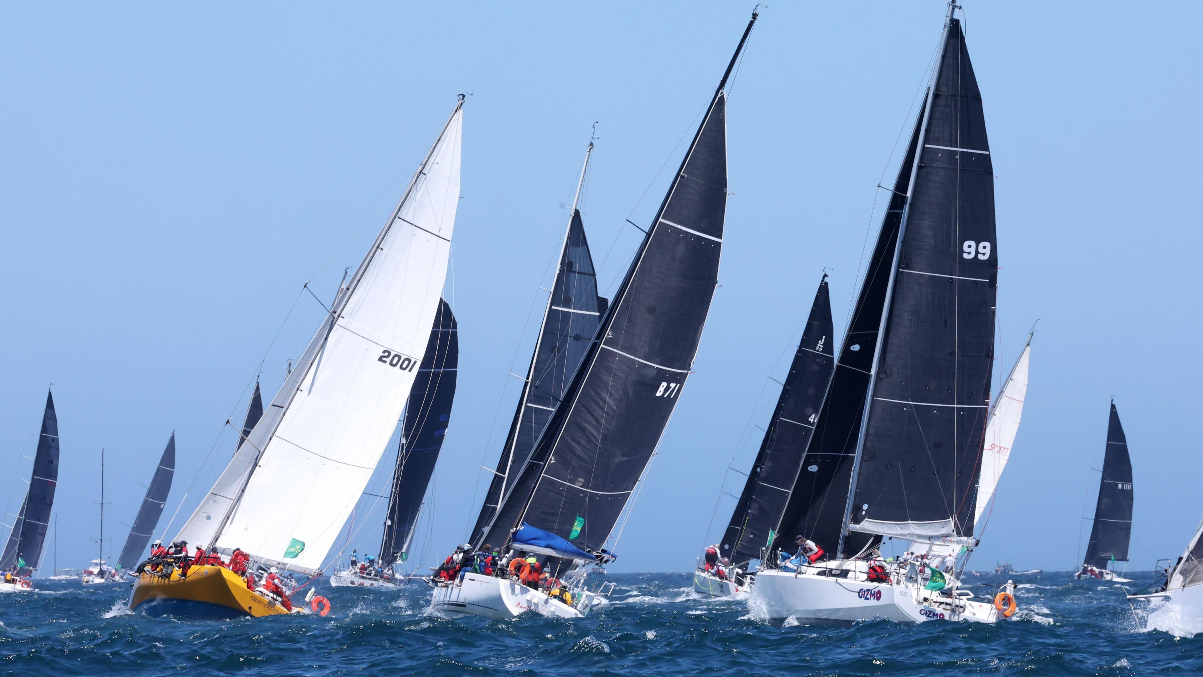 The fleet sails out of the Sydney Heads during the 2024 Sydney Hobart Yacht Race in Sydney