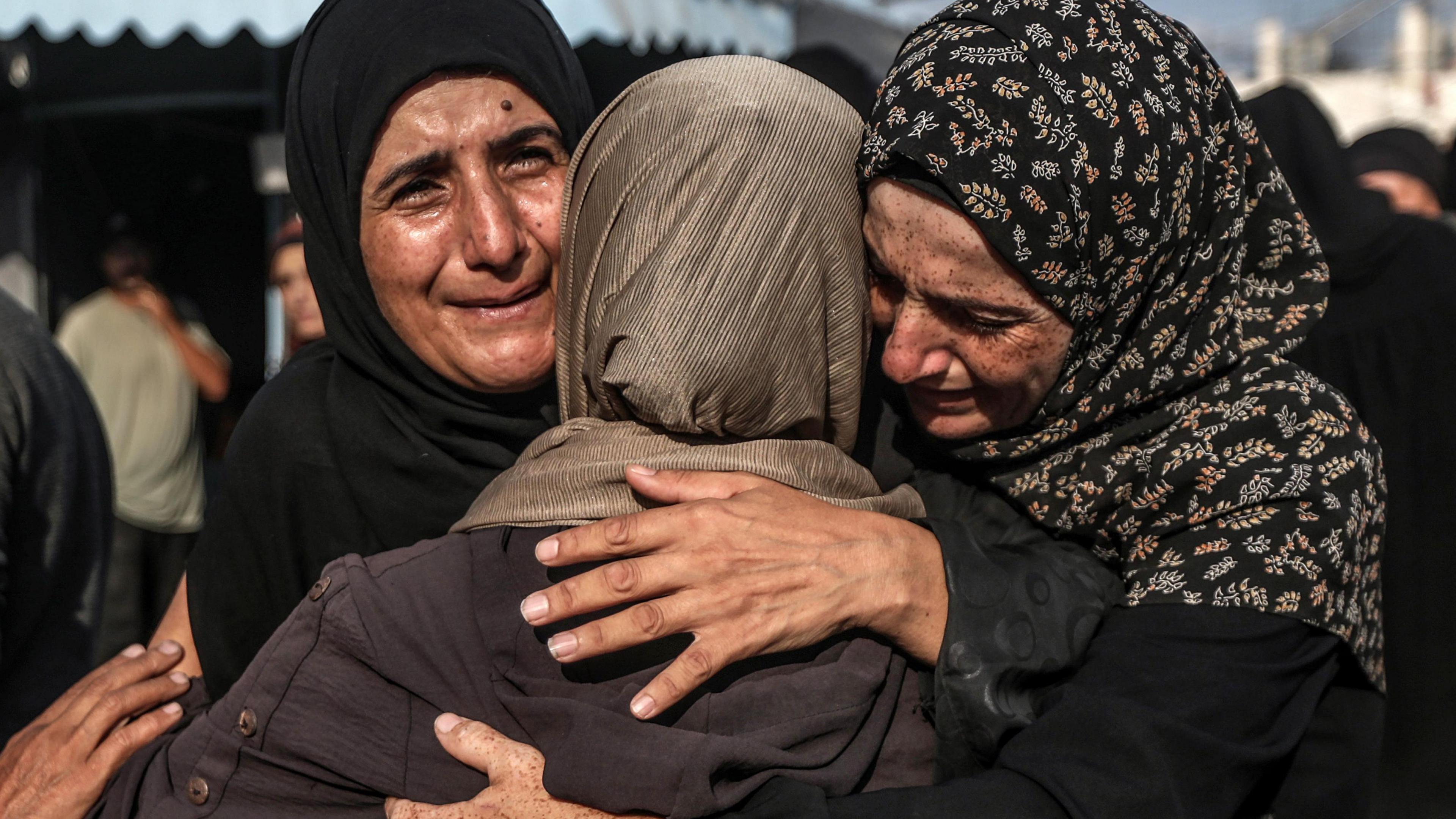 A group of relatives mourn during the funeral of Palestinians killed in an Israeli airstrike in Deir Al-Balah in Gaza on 6 October