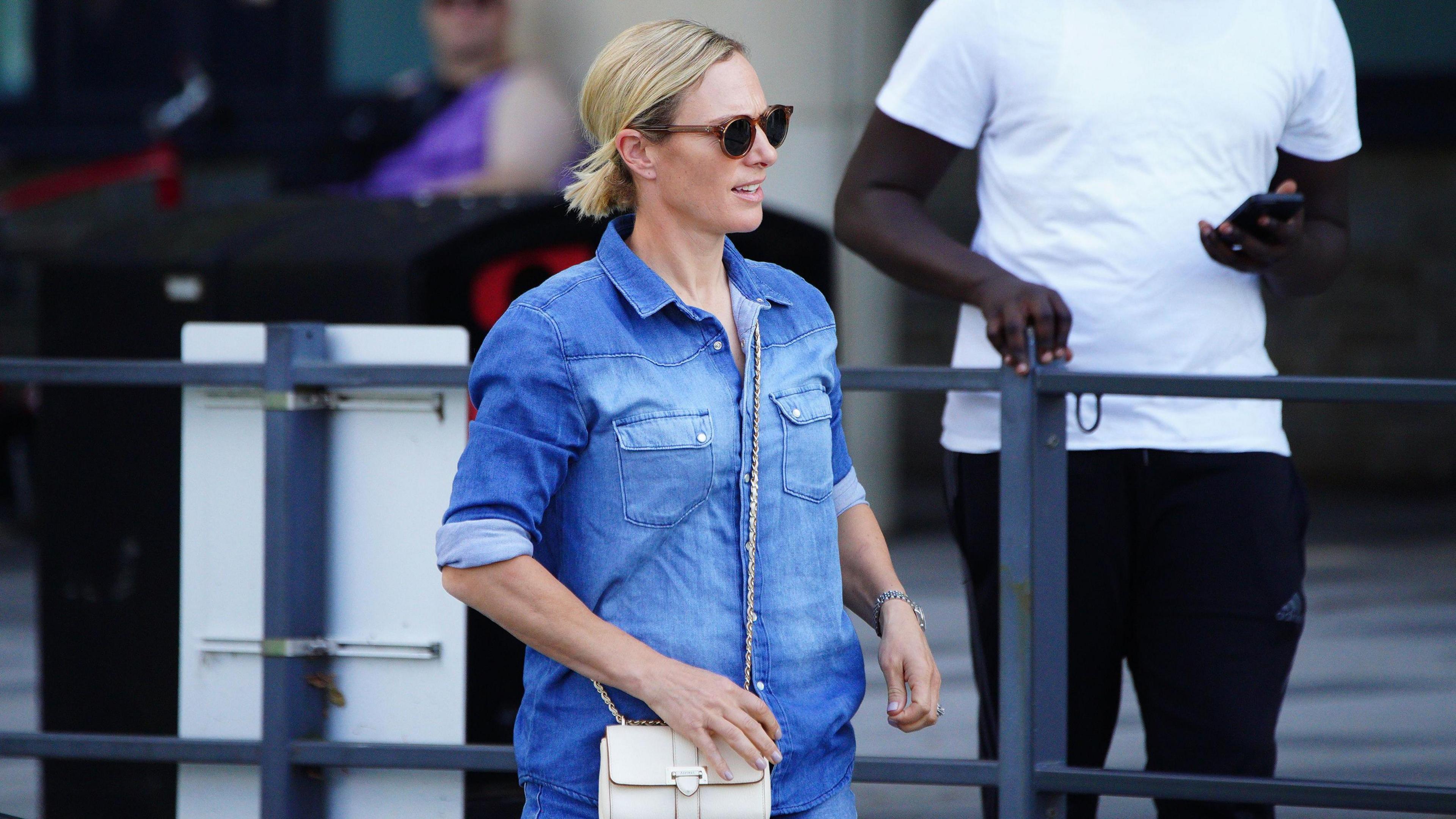 Zara Phillips walks out of Southmead Hospital in Bristol in Bristol. She is wearing a blue top and shorts and carrying a white handbag