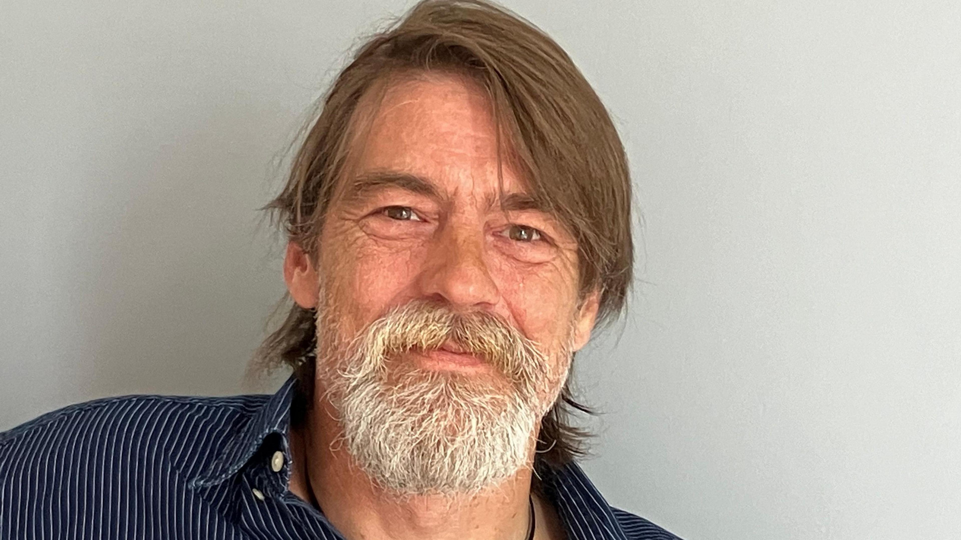 Man with beard wearing blue striped shirt 