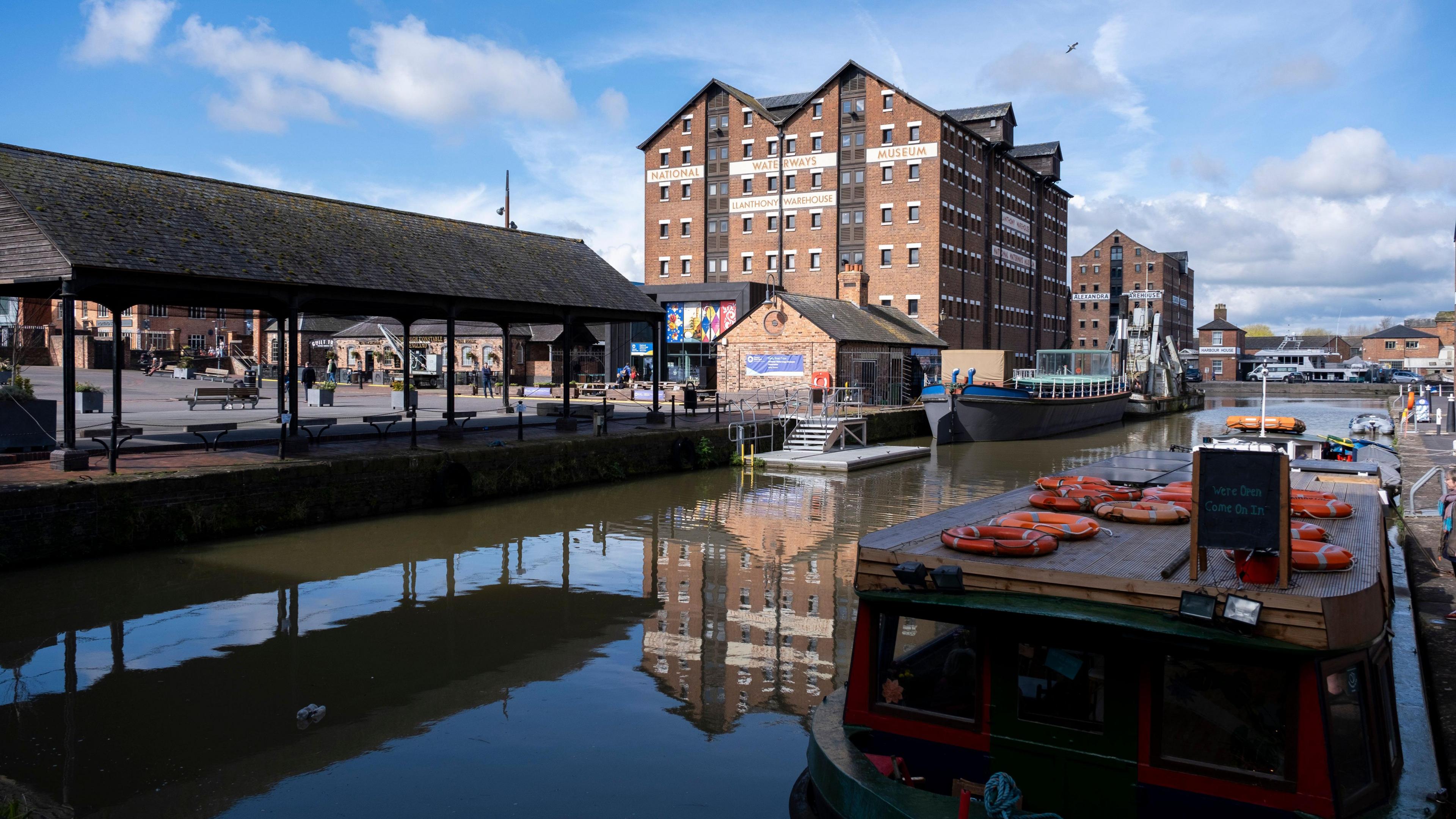 Gloucester Docks. Buildings can be seen as well as a boat in the water. 