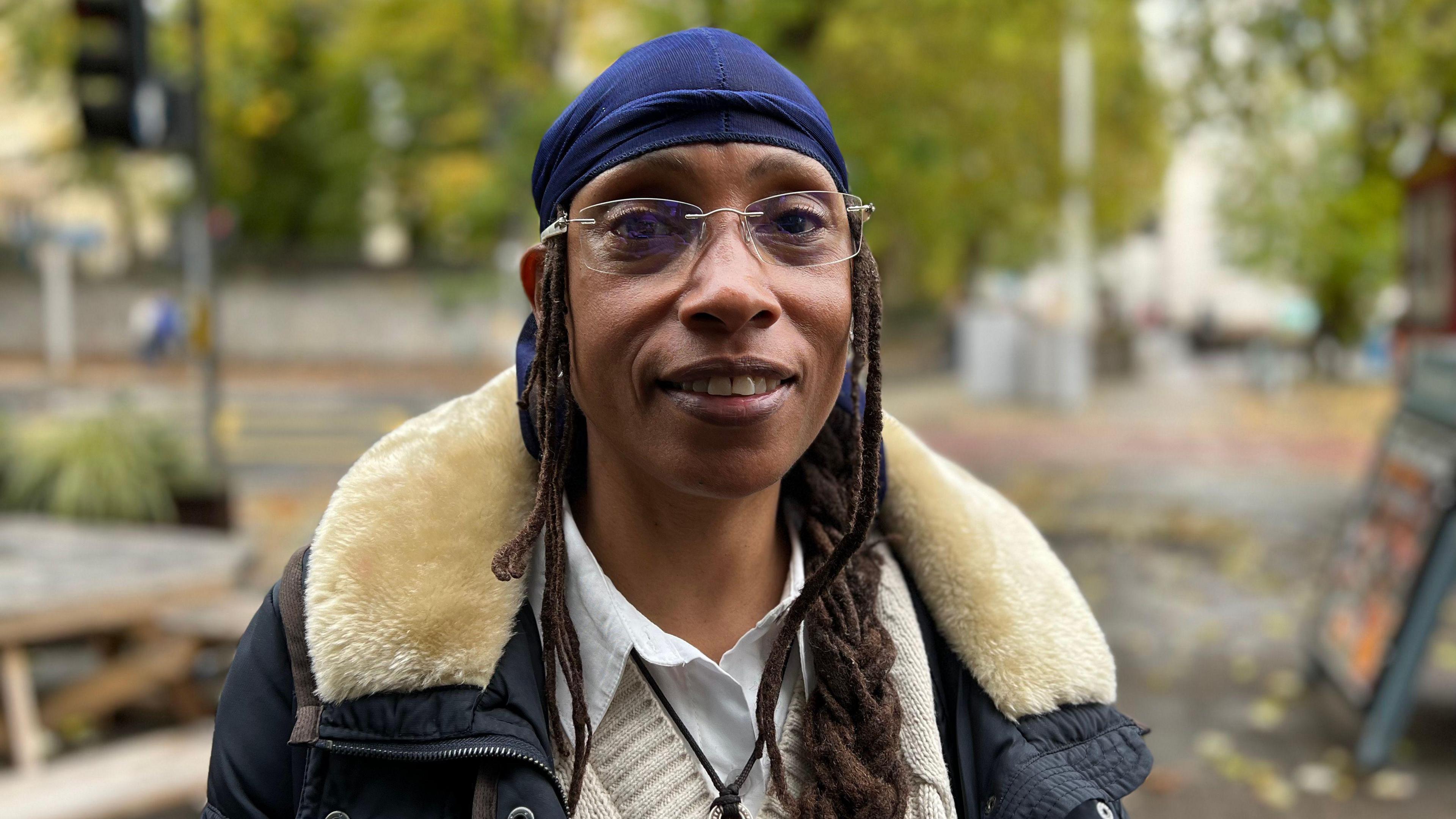 Marcia Brown is wearing a jacket and is smiling at the camera. 