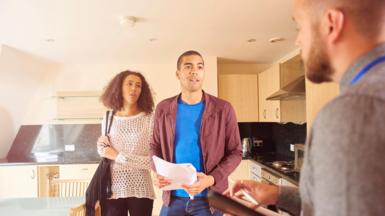 A couple talking to an estate agent during a flat viewing