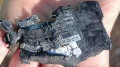 A hand shows a destroyed pager 