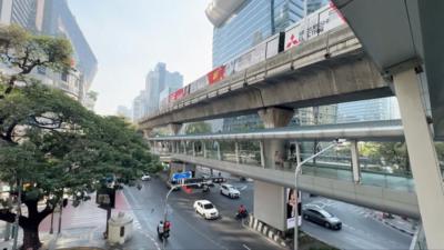 Picture shows a train going past above a busy road in Thailand