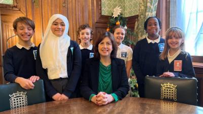 Lucy Powell with six school children. 