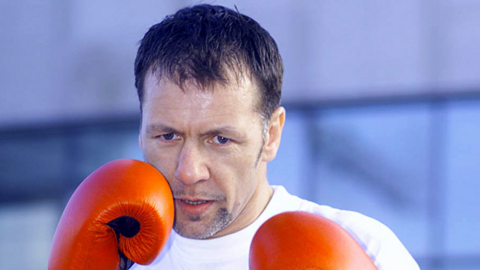 Boxer Billy Murray wearing red boxing gloves looking into the camera lens