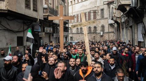 men in damascus carrying crosses during protest