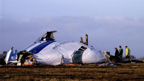 The wreckage of flight Pam Am 103 in Lockerbie. Police officers inspect the area around the nose of the aircraft.